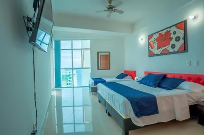 a bedroom with two beds and a television in it at Apartamento Vista Mar 1707 in Cartagena de Indias