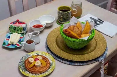 a table with two plates of food and a basket of bread at Voilá Signature Casa Isabel in Cartagena de Indias