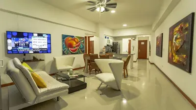 a living room with white chairs and a tv at Poseidon Lake Apartments in Cartagena de Indias