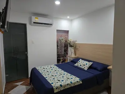 a bedroom with a bed with a blue comforter at Hotel Plaza 43 in Barranquilla