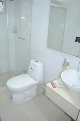 a white bathroom with a toilet and a sink at Hotel Sofichic Barranquilla in Barranquilla