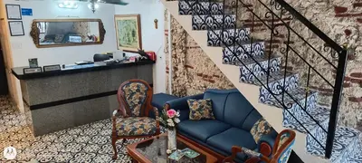 a living room with a blue couch and a staircase at Hostal Casa de las Americas in Cartagena de Indias