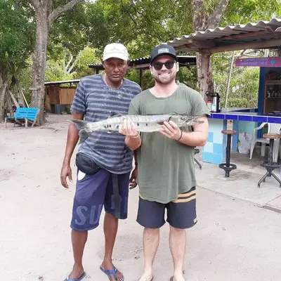 two men are holding a fish in their hands at Ecohotel Arte y Aventura in Isla Grande