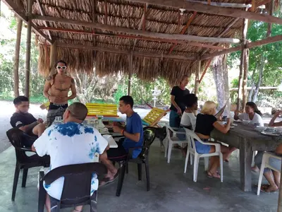 a group of people sitting at tables in a restaurant at Ecohotel Arte y Aventura in Isla Grande