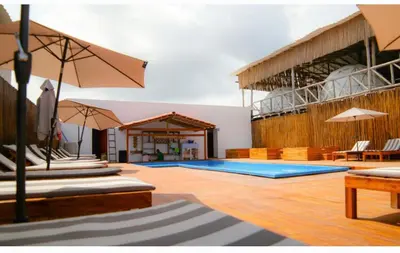 a pool with tables and umbrellas in a building at La Cabaña Glamping Geronimo in Playa Blanca