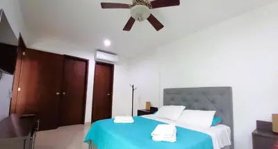 a bedroom with a blue bed with a ceiling fan at Apartasuite Morros Vitri in Cartagena de Indias