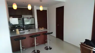 a kitchen with a counter with stools and a sink at Apartasuite Morros Vitri in Cartagena de Indias