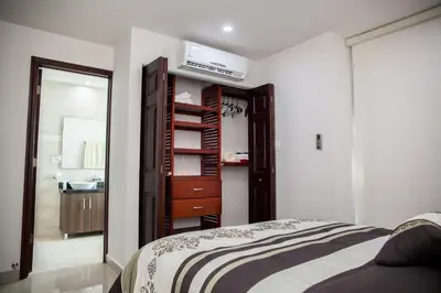 a bedroom with a bed and a bathroom with a sink at Cartagena Beach Front in Cartagena de Indias