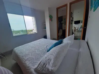 a bedroom with a bed with pillows and a window at Bello Horizonte * Unido Al Mar in Santa Marta