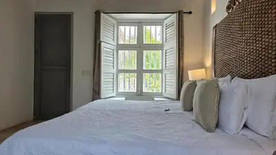 a bedroom with a large white bed with a window at Hotel Casa la Tablada in Cartagena de Indias