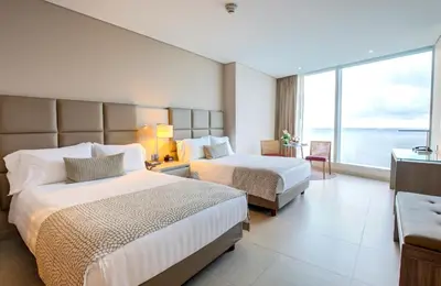 a hotel room with two beds and a large window at Estelar Cartagena de Indias Hotel y Centro de Convenciones in Cartagena de Indias