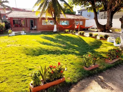 a green yard with flowers in pots in front of a house at Ortimar in Tolú