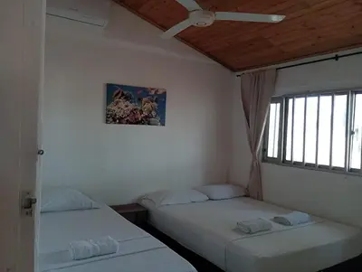 two twin beds in a room with a window at Ortimar in Tolú