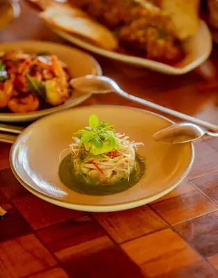 a plate of food with a salad on a table at Blue Apple Beach in Tierra Bomba