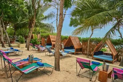 a group of chairs and tables on a beach at Blue Apple Beach in Tierra Bomba