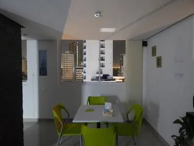 a dining room with a table and green chairs at Apartment Lux Bocagrande in Cartagena de Indias
