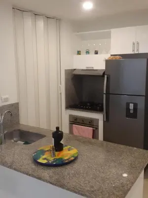 a kitchen with a surfboard on a counter with a refrigerator at Apartamento Morros Epic Cartagena in Cartagena de Indias