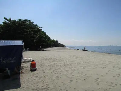 a beach with a person sitting on the sand at Costa Azul Suites 802 in Santa Marta