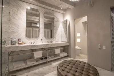 a bathroom with a sink and a mirror and a stool at Hotel Casa Noi in Cartagena de Indias