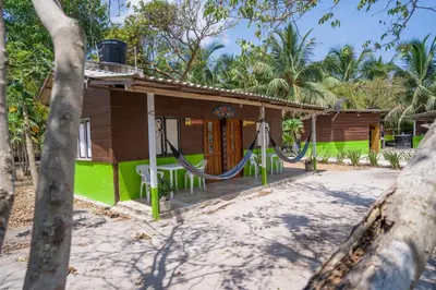 a house with a hammock in front of it at Eco Hotel Bosque Encantado in Isla Grande