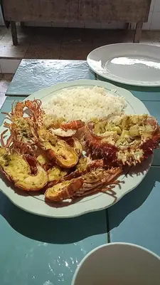 a plate of food with shrimp and rice on a table at ECOHOTEL LAS FLORES Econativo in Isla Grande