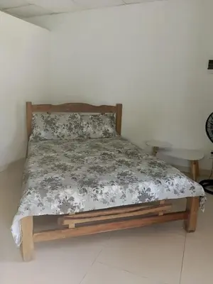 a bed in a white room with a wooden frame at ECOHOTEL LAS FLORES Econativo in Isla Grande