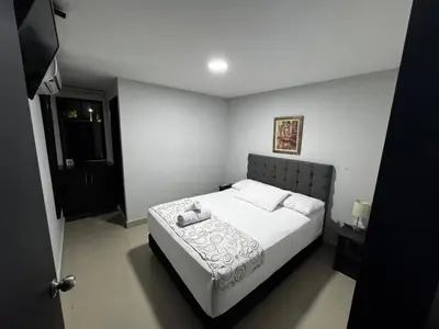 a bedroom with a bed with white sheets and pillows at Hotel Prado 53 in Barranquilla