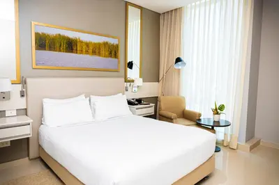 a bedroom with a large white bed and a desk at Crowne Plaza Barranquilla by IHG in Barranquilla