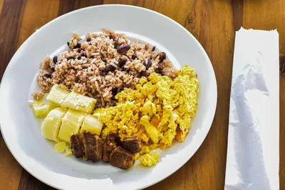 a plate of food with rice and meat and vegetables at Hotel Isla Capri in Cartagena de Indias