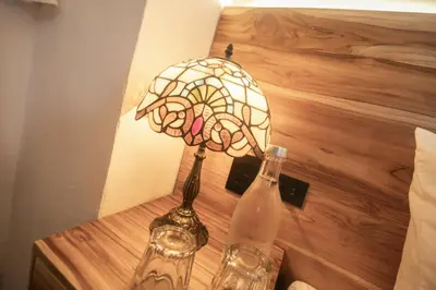 a stained glass lamp sitting on a table next to a bottle at Casa Be Getsemaní in Cartagena de Indias