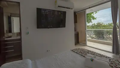 a living room with a bed and a large window at Hollywood Beach Suite in Cartagena de Indias
