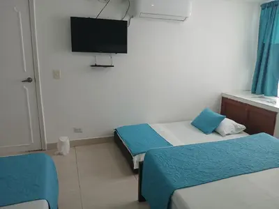 a room with two beds and a flat screen tv at Cartagena Linda 204 in Cartagena de Indias