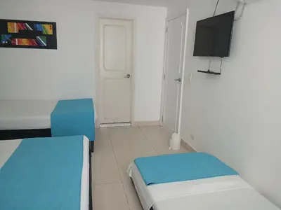 a small room with two beds and a flat screen tv at Cartagena Linda 204 in Cartagena de Indias