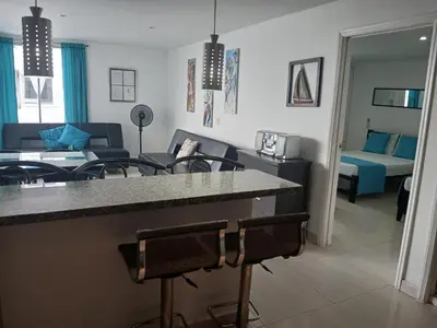 a kitchen and living room with a counter and chairs at Cartagena Linda 204 in Cartagena de Indias