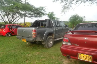 a gray truck parked next to a red car at Cabana Dubai Resorts in Santa Veronica