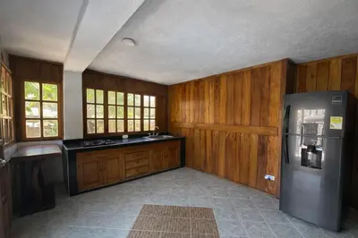 a kitchen with wooden cabinets and a refrigerator at Cabana Dubai Resorts in Santa Veronica