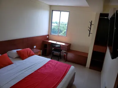 a bedroom with a bed and a desk and a window at Hotel Sandiego inc in Barranquilla