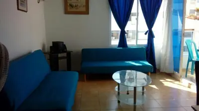 a living room with two blue couches and a glass table at Apartamento Playero in Cartagena de Indias