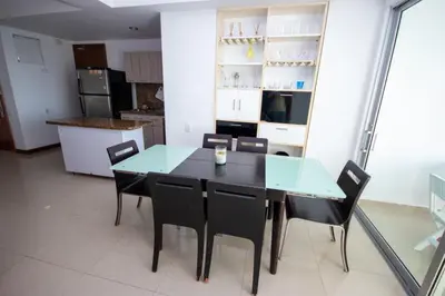 a dining room with a glass table and chairs at Excelente Apartamento Palmetto con vista al mar in Cartagena de Indias