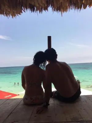 a couple sitting on the beach looking at the ocean at Cabaña Luna Azul in Playa Blanca