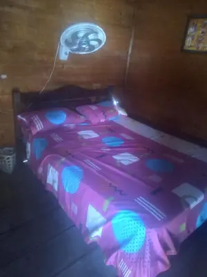 a bed with a pink and blue comforter in a room at Cabaña Luna Azul in Playa Blanca