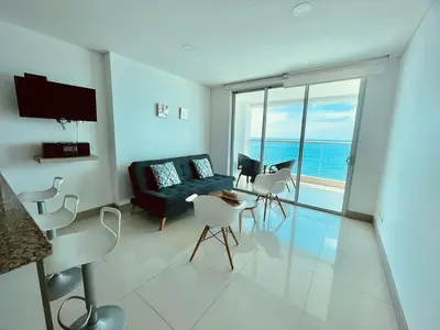 a living room with a couch and a table and chairs at Apartamento Frenta a la Playa in Cartagena de Indias