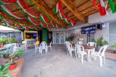 a restaurant with tables and white chairs and flags at Hotel Baly Express in Malambo