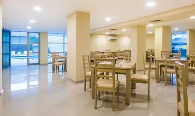 a dining room with tables and chairs in a restaurant at Ribai Hotels - Barranquilla in Barranquilla