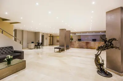 a lobby of a building with a sculpture in the middle at Ribai Hotels - Barranquilla in Barranquilla