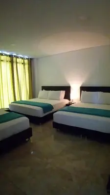 two beds sitting in a room with at Hotel La Mar Cartagena in Cartagena de Indias