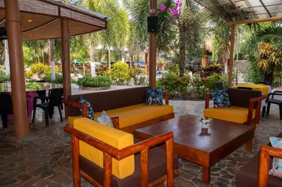 a patio with tables and chairs and a table with at Hotel Isla Real in Tierra Bomba