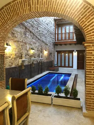 a swimming pool in a house with an archway at Akel House Hotel in Cartagena de Indias