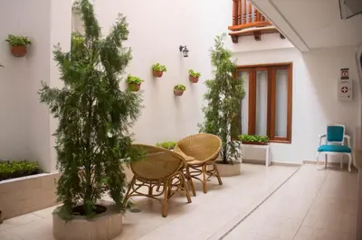 a patio with chairs and potted trees in a building at Akel House Hotel in Cartagena de Indias