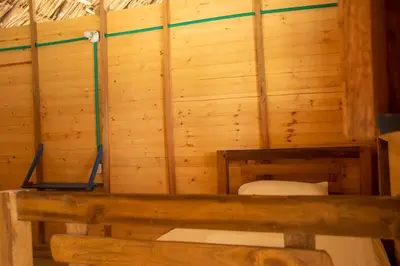 a bathroom with a toilet in a wooden wall at Isla Múcura Dahlandia in Isla Mucura